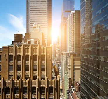 shutterstock view of sunrise between manhattan high rise buildings