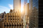 shutterstock view of sunrise between manhattan high rise buildings