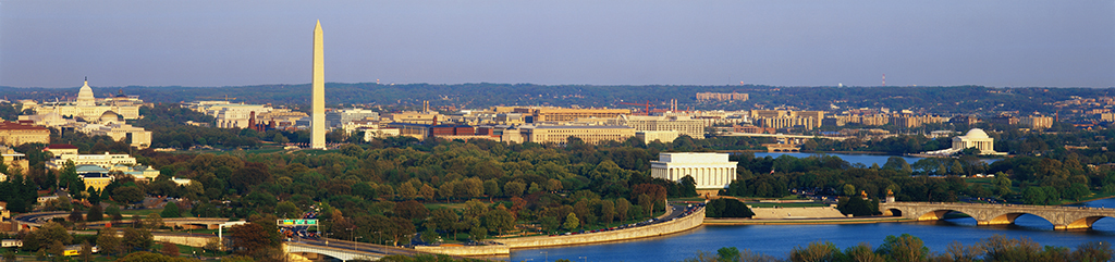 aerial view of Washington, DC. The Potomac River runs through the center with the Key Bridge at right at sunset.