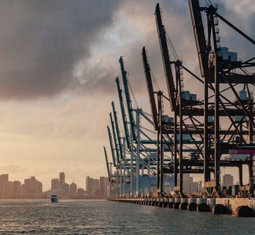 Aerial view of cranes in the Port of Miami with the Miami skyline in the background