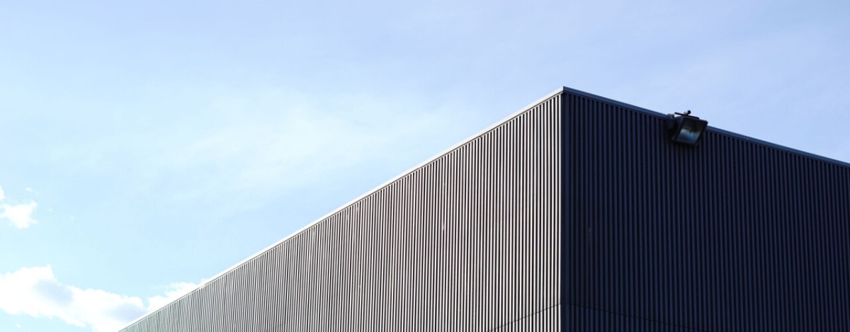 partial view of the outside roof line and corner of a warehouse building
