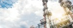 Towers of an industrial plant with sky and clouds as background