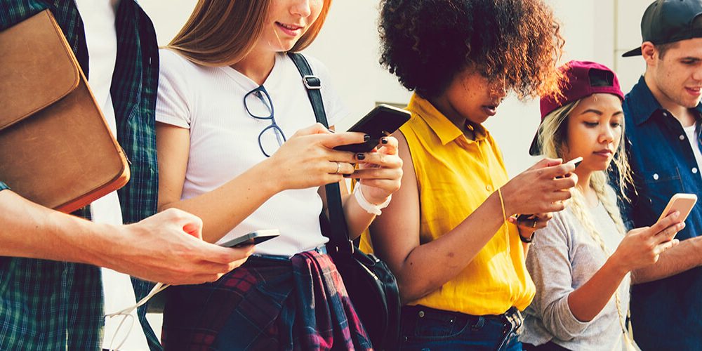 Image of young people, Gen Z, using their smartphones