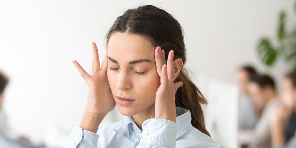 Young woman frustrated by her coworkers' office behaviors