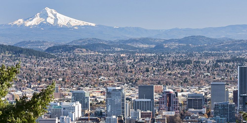 A wide shot of the skyline of Portland, OR with Mount Hood in the background