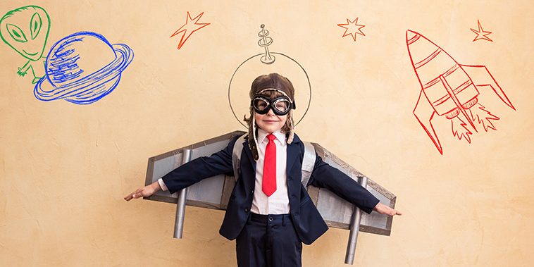 boy in business suit with rocket wings preparing to take flight