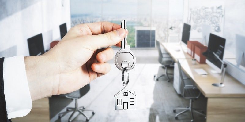 broker hand holding out key to turnkey office space