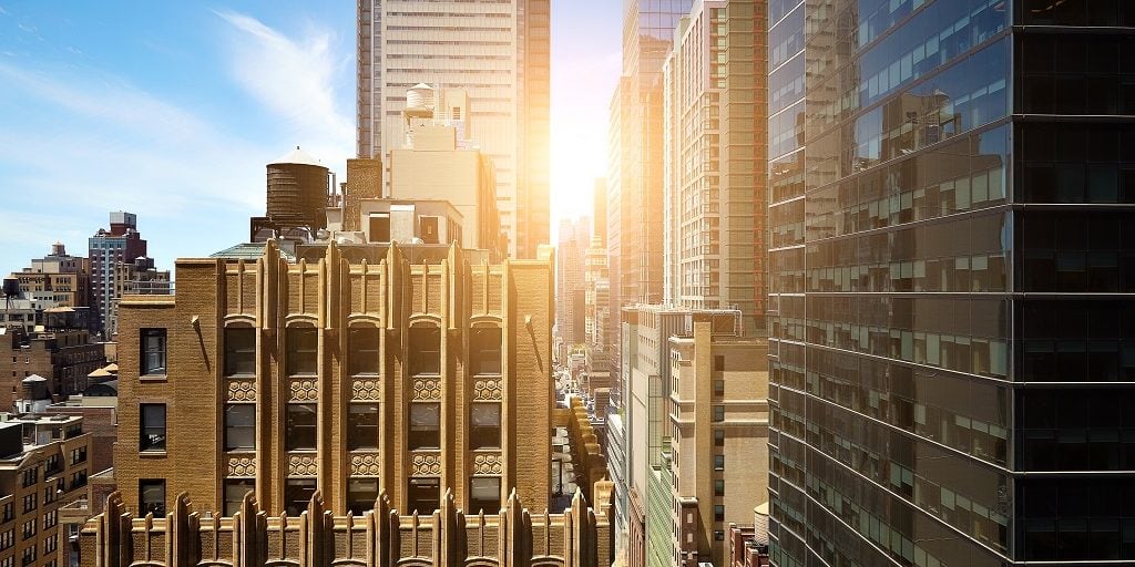 shutterstock view of sunrise between manhattan high rise buildings