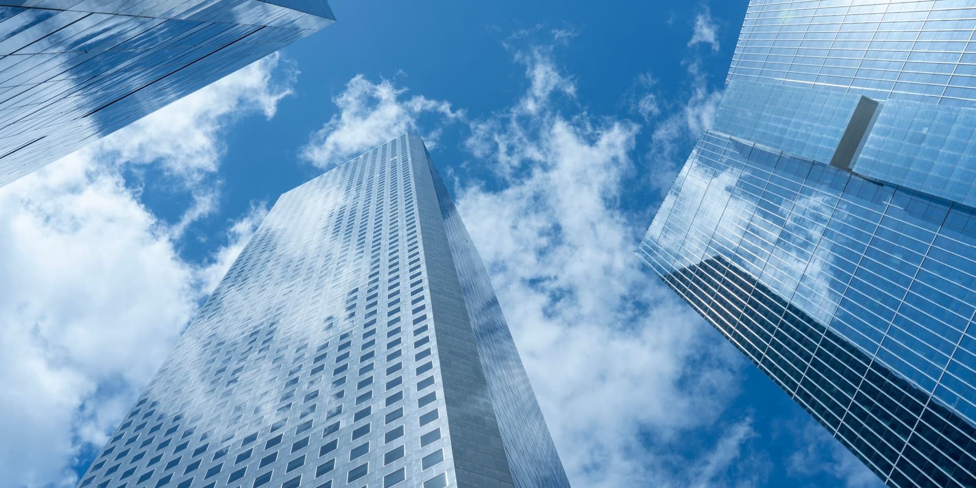 vertical view of modern office buildings facing up from the ground level