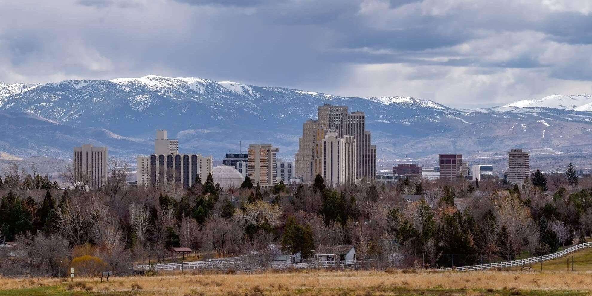 landscape view of the Reno central business district with snowcapped mountains in the distance beyond