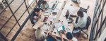 Multiracial group of people sitting at a table in a coworking hub