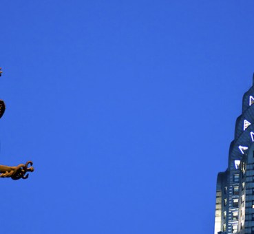 view of top of chrysler building in new york city and statue of mercury on grand central terminal