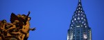 view of top of chrysler building in new york city and statue of mercury on grand central terminal