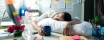 Image of female employee napping at her desk due to exhaustion