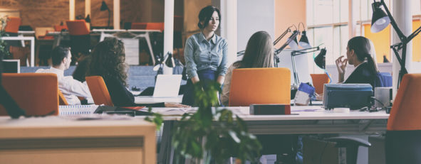 Several people sitting and standing in an office