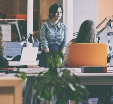 Several people sitting and standing in an office