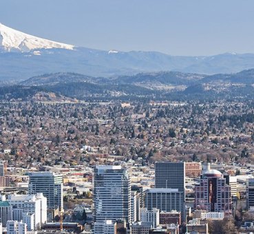 A wide shot of the skyline of Portland, OR with Mount Hood in the background