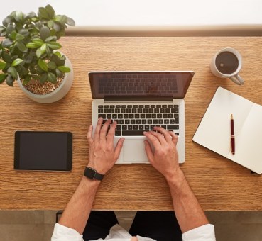 Professional making plan at laptop taking notes
