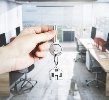 broker hand holding out key to turnkey office space