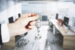 broker hand holding out key to turnkey office space